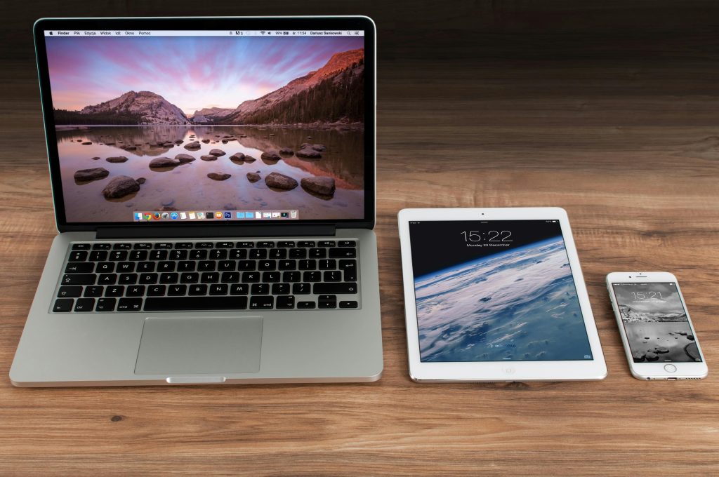 Ein Macbook liegt neben einem iPad und einem iPhone